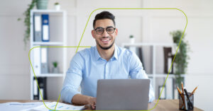 imagem de pessoa com notebook sorrindo em um escritório de tela branca