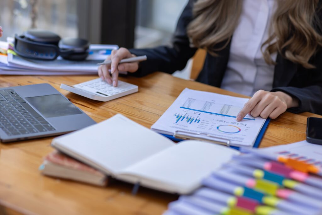 imagem de mulher trabalhando com gráficos e calculadora