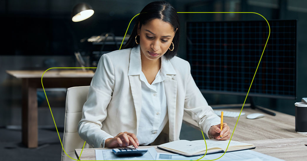 imagem de pessoa mexendo na calculadora e papéis fazendo cálculos