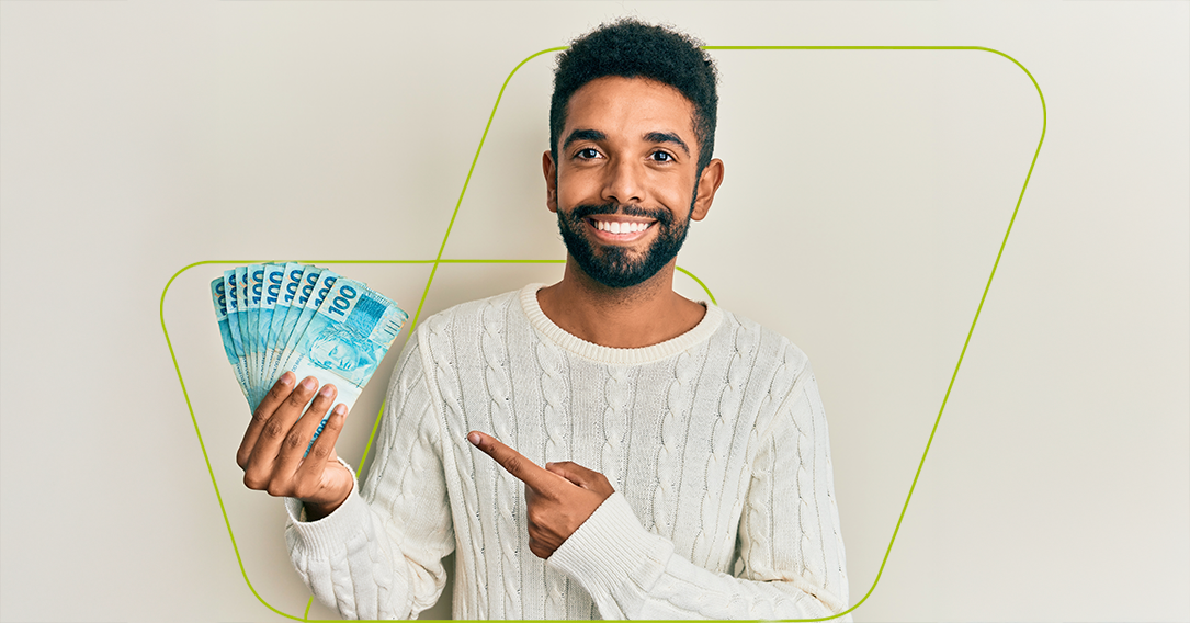 Imagem de pessoa segurando dinheiro com notas de 100 reais