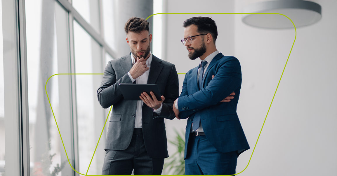 Imagem de dois empresários olhando para tela do tablet